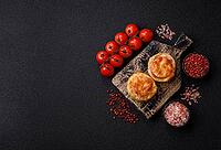 Round fish or chicken cutlets baked with tomato and cheese. Fish cutlets as a food backdrop for your design [IBR124865310]