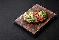 Food, Delicious brown bread toast with salmon, avocado, cucumber and sesame seeds on a textured concrete background [IBR124876413]