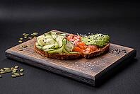 Food, Delicious brown bread toast with salmon, avocado, cucumber and sesame seeds on a textured concrete background [IBR124876419]