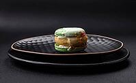 Food, Beautiful tasty macaron with filling and fruit flavor on a black plate on a dark concrete background [IBR124876426]