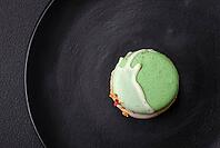 Food, Beautiful tasty macaron with filling and fruit flavor on a black plate on a dark concrete background [IBR124876430]