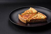 Food, Beautiful delicious quiche pie with four types of cheese with spices and herbs on a dark concrete background [IBR124876434]