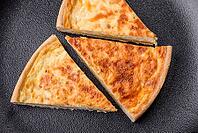 Food, Beautiful delicious quiche pie with four types of cheese with spices and herbs on a dark concrete background [IBR124876436]