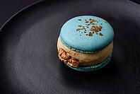 Food, Beautiful tasty macaron with filling and fruit flavor on a black plate on a dark concrete background [IBR124876437]