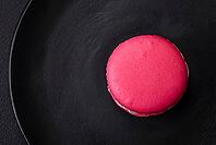 Food, Beautiful tasty macaron with filling and fruit flavor on a black plate on a dark concrete background [IBR124876438]