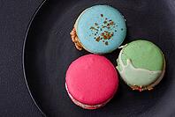 Food, Beautiful tasty macaron with filling and fruit flavor on a black plate on a dark concrete background [IBR124876439]
