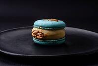 Food, Beautiful tasty macaron with filling and fruit flavor on a black plate on a dark concrete background [IBR124876445]