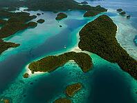 Aerial view of many small tropical islands with turquoise water and presented reefs and a sailing catamaran, Pulau Wayag, Raja Ampat, West Papua, Indonesia [IBR124899550]