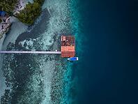 Aerial view from top to bottom of a jetty and a boat and a presented reef, Raja Ampat, West Papua, Indonesia [IBR124899552]