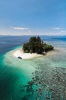 Aerial view of a small tropical island with turquoise water, white sandy beach, a boat and a proposed reef, Raja Ampat, West Papua, Indonesia [IBR124899555]