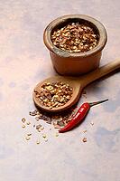 Chilli, chilli flakes in cooking spoon and pot, Capsicum annuum [IBR124899845]