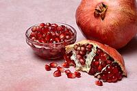 Opened pomegranate and pomegranate seeds in skin, Punica granatum [IBR124899847]