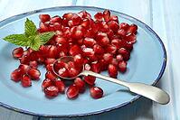 Pomegranate seeds and spoons on plate, Punica granatum [IBR124899851]