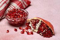 Opened pomegranate and pomegranate seeds in skin, Punica granatum [IBR124899854]