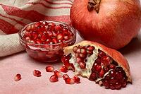 Opened pomegranate and pomegranate seeds in skin, Punica granatum [IBR124899860]