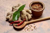 Ginger, ginger root with kaffir lime leaf and chili pepper and chilli flakes in pot [IBR124899863]