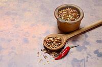 Chilli, chilli flakes in cooking spoon and pot, Capsicum annuum [IBR124899870]