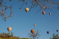 Scenic morning view of colorful hot air balloons soaring over the unique Cappadocia landscape, Turkey [IBR124899887]