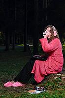 Happy woman is working on laptop at forest in undress [IBR124906338]