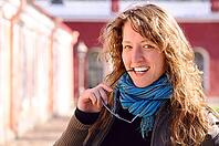 Beautiful smart woman is looking at camera and biting her glasses [IBR124906348]