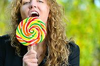 Woman is licking a huge lollipop [IBR124906359]