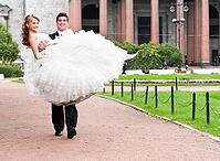 Groom is carrying bride on arms on city park road [IBR124906370]