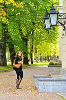 Woman is walking at autumn city park [IBR124906382]