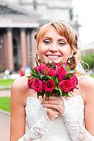 Cheerful bride is holding wedding bunch of roses [IBR124906383]