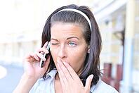 Funny woman is yawning when talking phone [IBR124906393]