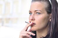 Closeup of a pretty woman smoking at the street [IBR124906419]