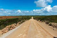 View of a gravel path leading through nature to the coast, under a slightly cloudy sky, near Setubal in spring 2019 [IBR124915271]