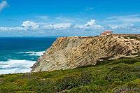 View of a rocky coast by the sea under a slightly cloudy sky, near Setubal in spring 2019 [IBR124915279]