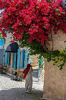 Traveling woman captures images while exploring charming old town architecture and culture [IBR124920167]