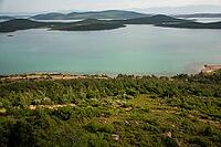A tranquil panorama of Ayvalık's emerald islands and calm waters unfolds beneath soft, drifting clouds [IBR124920168]