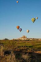 Scenic morning view of colorful hot air balloons soaring over the unique Cappadocia landscape, Turkey [IBR124920190]