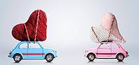 Couple of retro toy cars delivering craft hearts for Valentine's day on gray background [IBR124944051]