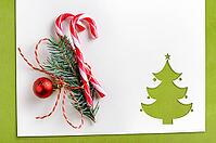 Cut paper in christmas tree shape with decoration for christmas card or new year background on green table [IBR124944056]