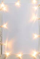 Christmas lights on gray table with paper sheet, view from above [IBR124944073]