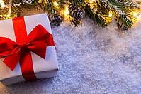 Christmas fir tree with lights and gift box on snow in dark, view from above [IBR124944079]