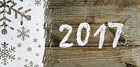 Christmas card or new year background made of snowflakes symbols handwritten on snow and wooden table [IBR124944087]