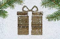 Christmas card or new year background made of gift box handwritten on snow and fir-tree branches over wooden table [IBR124944096]