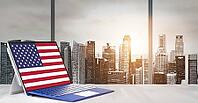 Independence Day on office laptop screen with panoramic sunset view of modern downtown skyscrapers at business district [IBR124944104]