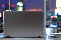 Laptop on table in office with panoramic night view of modern downtown skyscrapers at business district [IBR124944125]