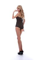 Portrait of beautiful blonde model poses in polka-dot body on white [IBR124968433]