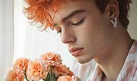Closeup portrait of a young man with peach-colored hair, silver earrings, holding peach carnations. AI generated [IBR125000297]