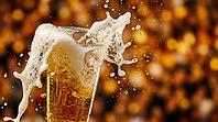 Extreme macro close-up of clear plastic stadium cup of golden beer with foam violently overflowing rim in multiple directions simultaneously from sudden movement, dense white-cream foam cascade mid-fall over left edge with individual beer droplets airborn [IBR125000334]