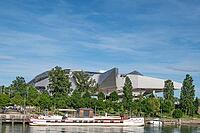 The deconstructivist architecture of the Musée des Confluences, designed by the Viennese architectural firm Coop Himmelb (l) au, on the banks of the Saône at Quai Rambaud, with a traditional péniche moored by the river against a backdrop of green trees, s [IBR125002341]