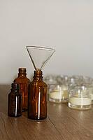Dark glass bottles with glass funnel, in the background glasses with homemade cream, Kempen, Viersen district, North Rhine-Westphalia, Germany [IBR125007622]