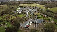 Aerial view of a rural manor surrounded by well-kept gardens and trees, set in a countryside landscape, Farm in Wales, United Kingdom [IBR125026137]