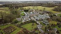 Aerial view of a large rural estate with various buildings and gardens surrounded by fields and trees, Farm in Wales, United Kingdom [IBR125026138]